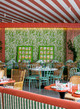 Interior of Sushita Green Café in Madrid featuring Mille Feuilles standard wallpaper in Grass by Raoul Dufy. Styled with Ozone and La Jungle fabrics in coordinating green tones for a lush, layered look.